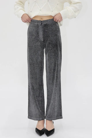 Person wearing gray wide-leg pants with a white textured top on a light gray background