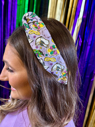 Woman wearing a colorful headband with a pattern against a vibrant curtain background